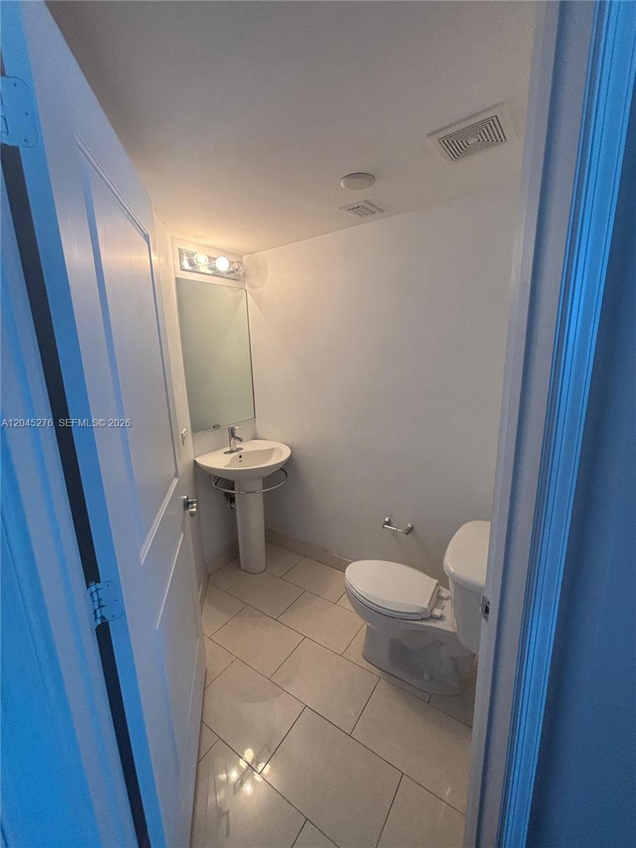 An empty room with dark wood flooring, track lighting, and a balcony with city views — 480 NE 30th St # 1004, Miami FL 33137, MIAMI, FL