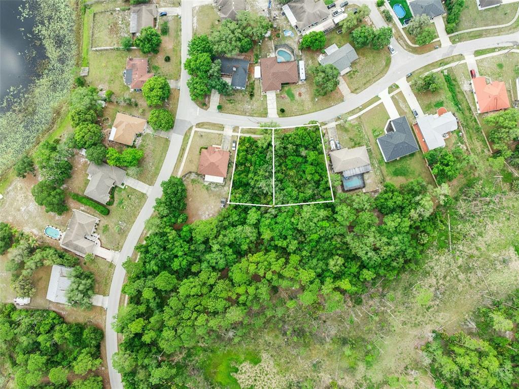 This aerial view shows two adjacent wooded residential lots situated in a suburban neighborhood — 1680  & 1672 GREGORY DRIVE, DELTONA, FL