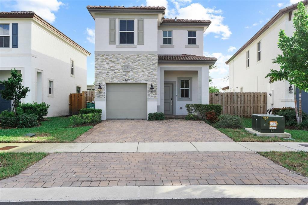 A two-story house with a stone facade, a single-car garage, and a paved driveway — 2441 NW 131st Circle # 2441, Miami FL 33167, MIAMI, FL
