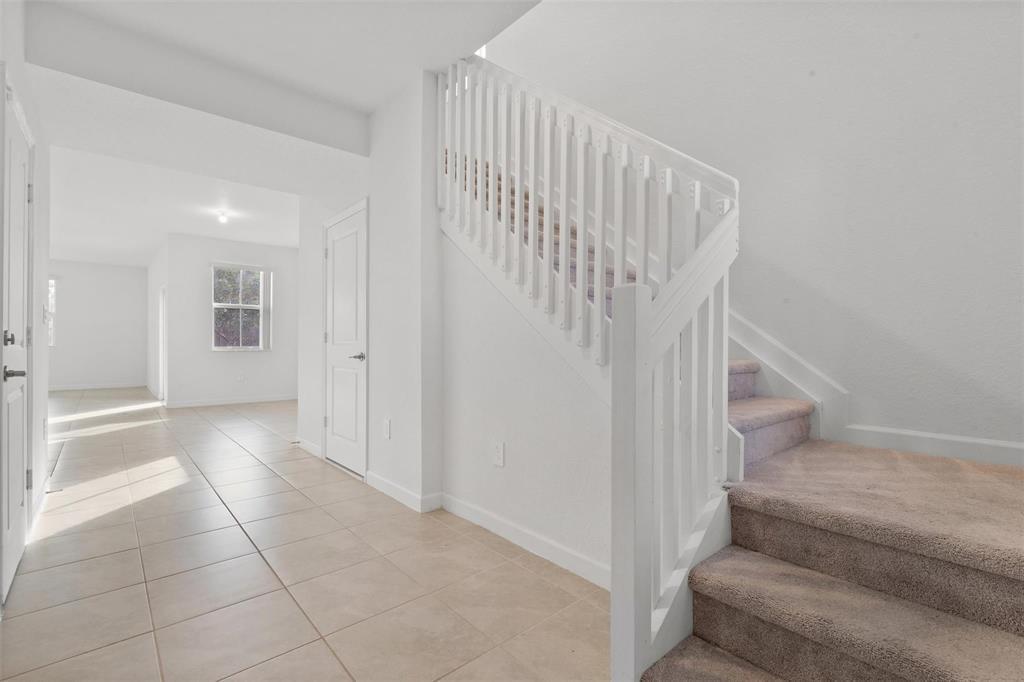 A tiled entryway leads to a carpeted staircase with a white wooden railing — 2441 NW 131st Circle # 2441, Miami FL 33167, MIAMI, FL