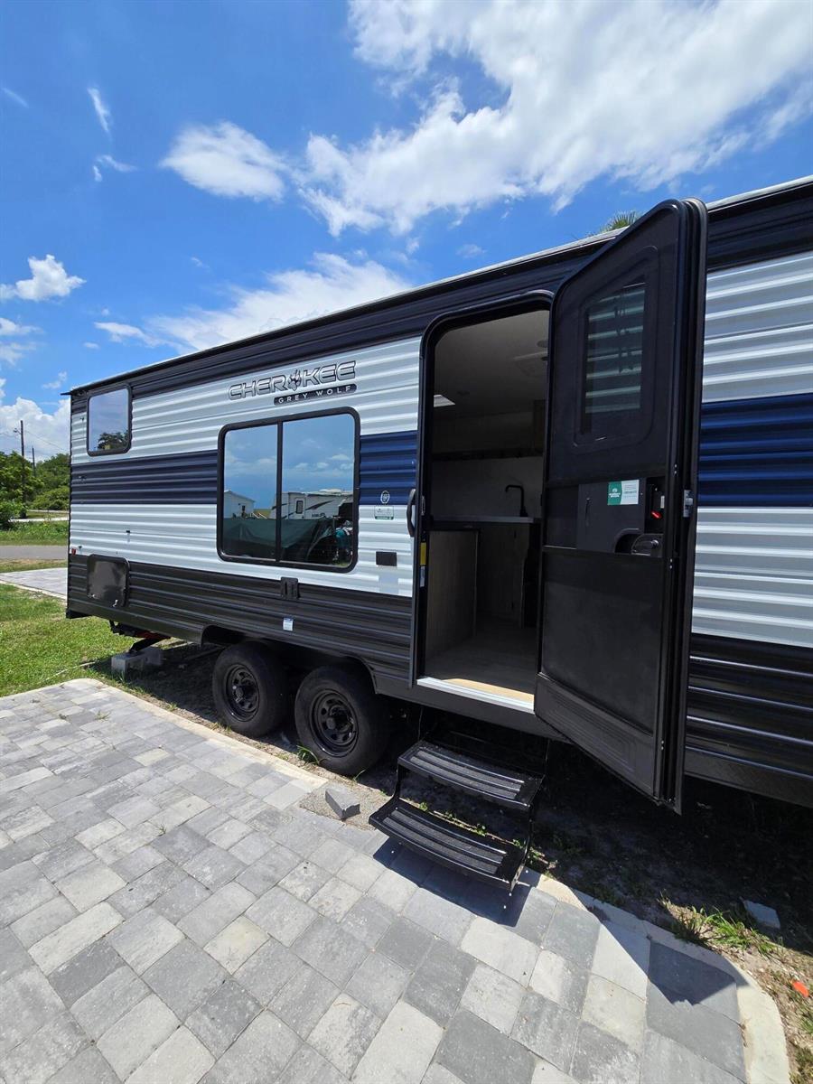 A side view of a Cherokee Grey Wolf travel trailer parked on a paved patio — 6640 Us Hwy Se 441 SE, Okeechobee FL 34974, OKEECHOBEE, FL