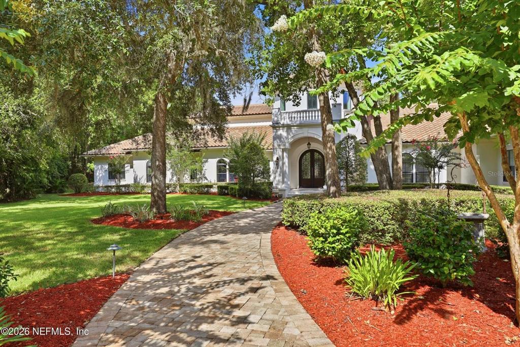 A paved walkway leads to the arched front entrance of a white stucco house — 3260 COUNTY ROAD 209, GREEN COVE SPRINGS, FL