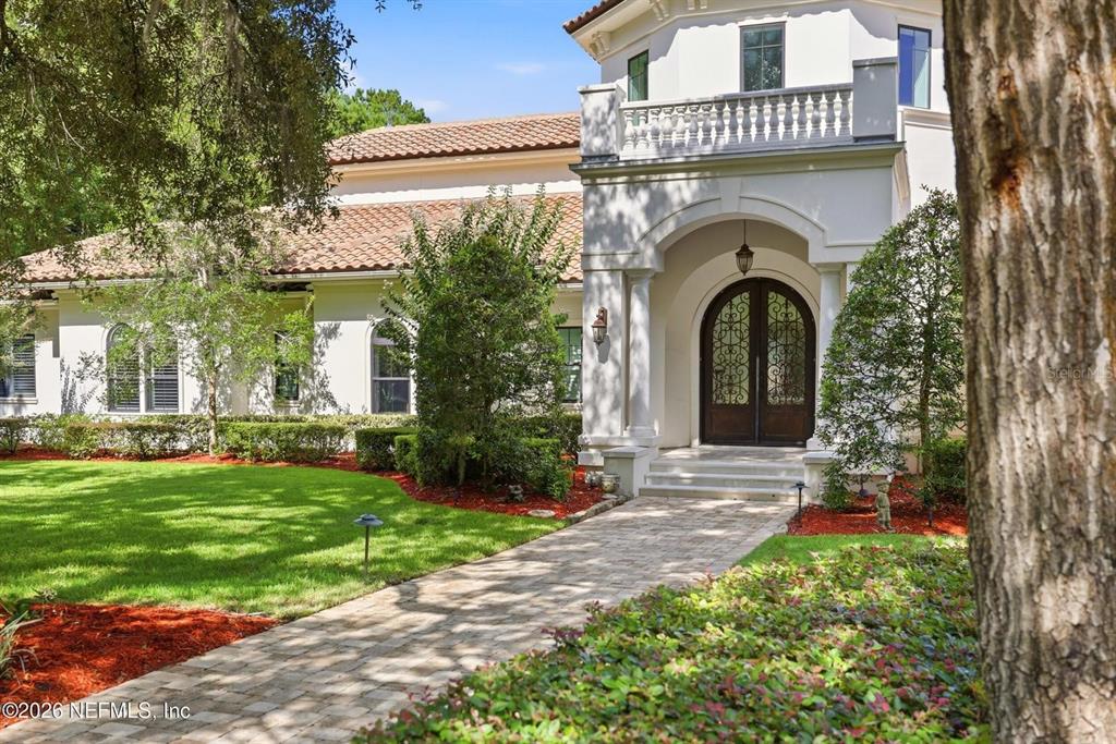 A paved walkway leads to the arched double-door entrance of a white stucco house — 3260 COUNTY ROAD 209, GREEN COVE SPRINGS, FL