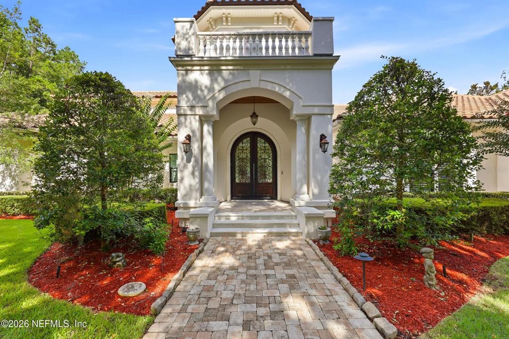 A stone walkway leads to the arched entryway of a stucco home with columns — 3260 COUNTY ROAD 209, GREEN COVE SPRINGS, FL