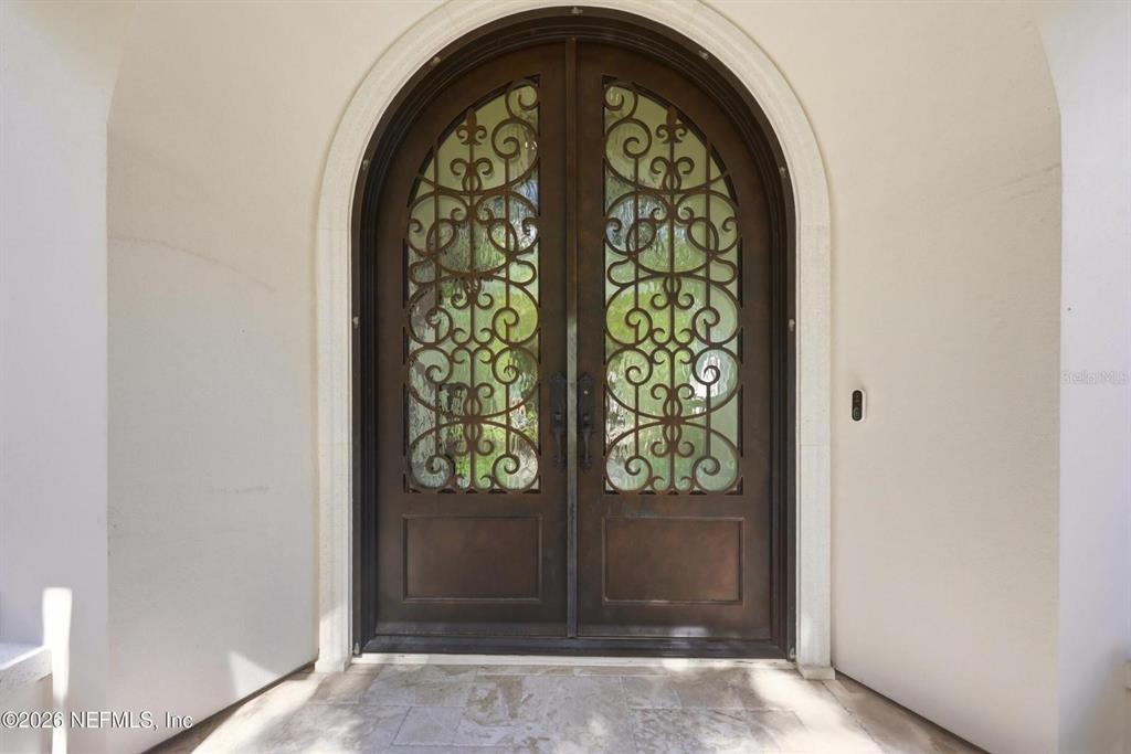 An arched double door with decorative ironwork sits within a stone entryway — 3260 COUNTY ROAD 209, GREEN COVE SPRINGS, FL