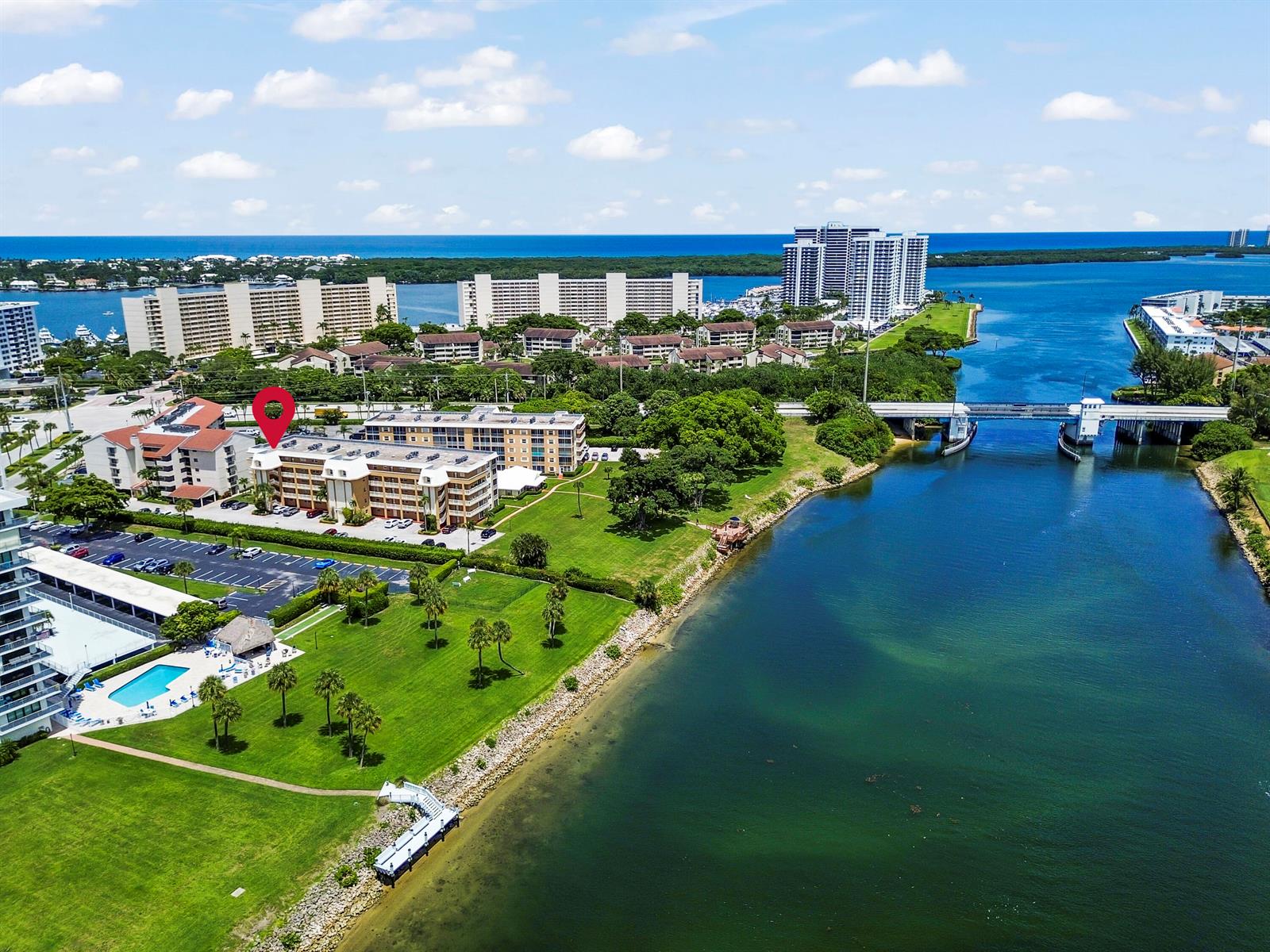 An aerial view shows a multi-story apartment complex with a pool, lawn, and nearby waterway — 308 Golfview Road # 101, North Palm Beach FL 33408, NORTH PALM BEACH, FL