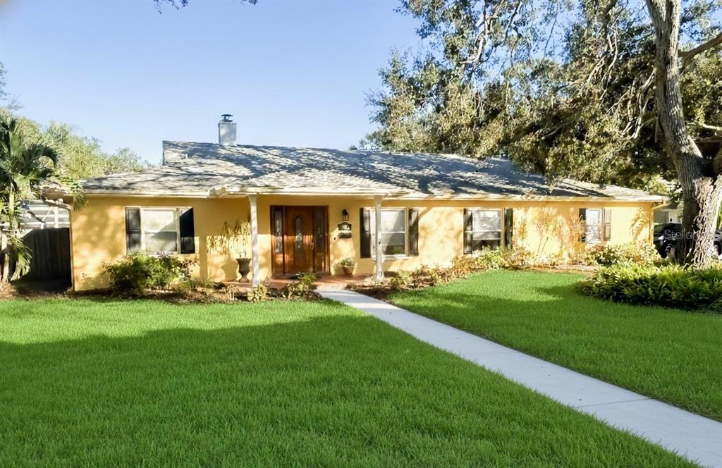 A single-story yellow house with a covered front porch and a concrete walkway — 5710 S BERNIE STREET, TAMPA, FL