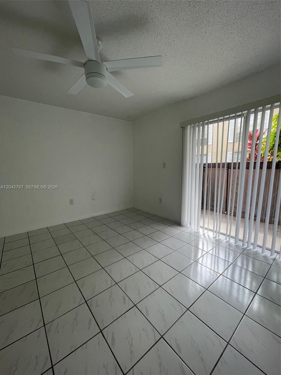 A room with white tile floors, a ceiling fan, and sliding glass doors to a balcony — 10832 SW 88th St # U13, Miami FL 33176, MIAMI, FL