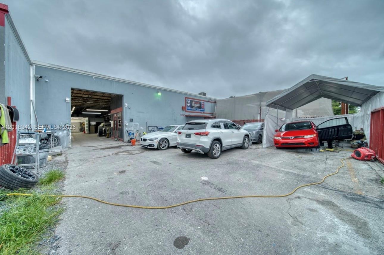 An exterior view shows a commercial building with a parking area and several parked cars — 3730 NW 82nd St, Hialeah FL 33147, HIALEAH, FL