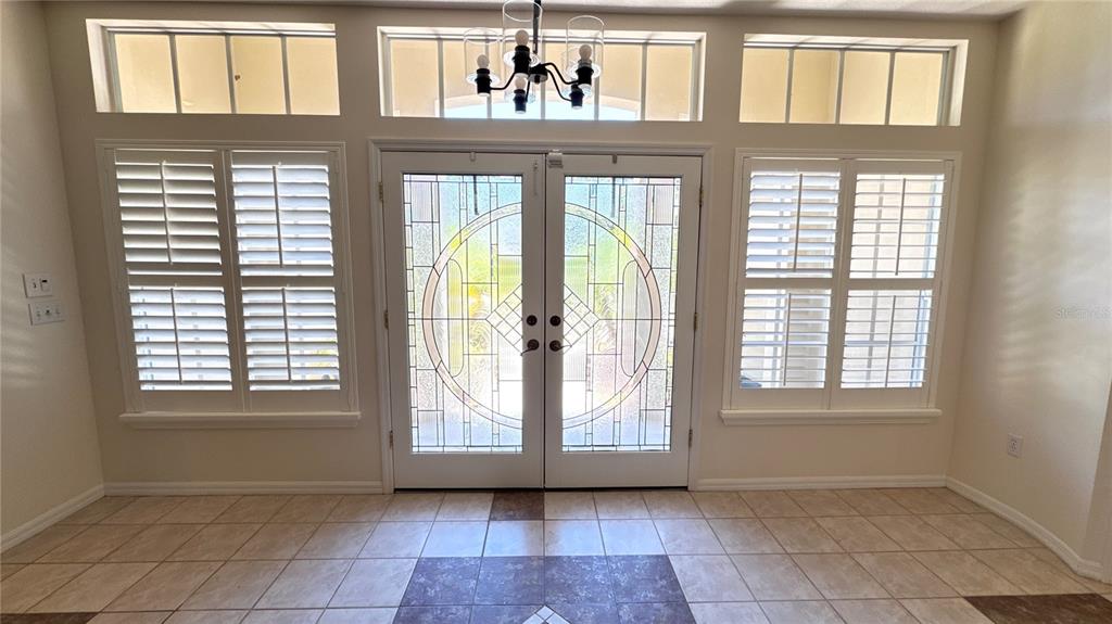 A single-story house with a tiled roof, two-car garage, and landscaped front yard — 1230 BERKSHIRE LANE, TARPON SPRINGS, FL