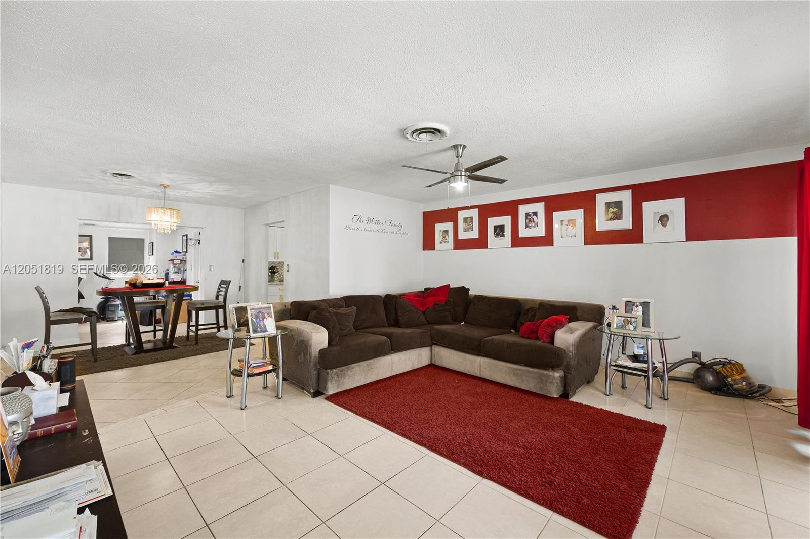 A living room features a brown sectional sofa, a red area rug, and a dining area — 761 NW 65th Ave, Margate FL 33063, MARGATE, FL