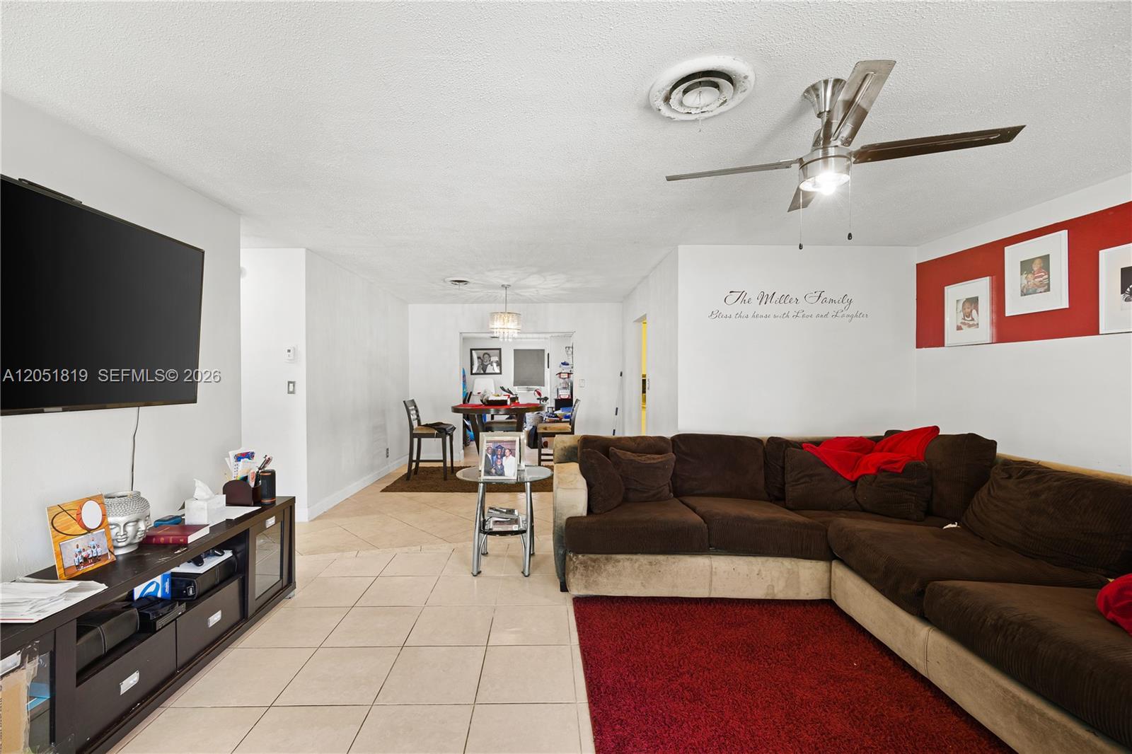 A living room features a brown sectional sofa, a red area rug, and a television — 761 NW 65th Ave, Margate FL 33063, MARGATE, FL
