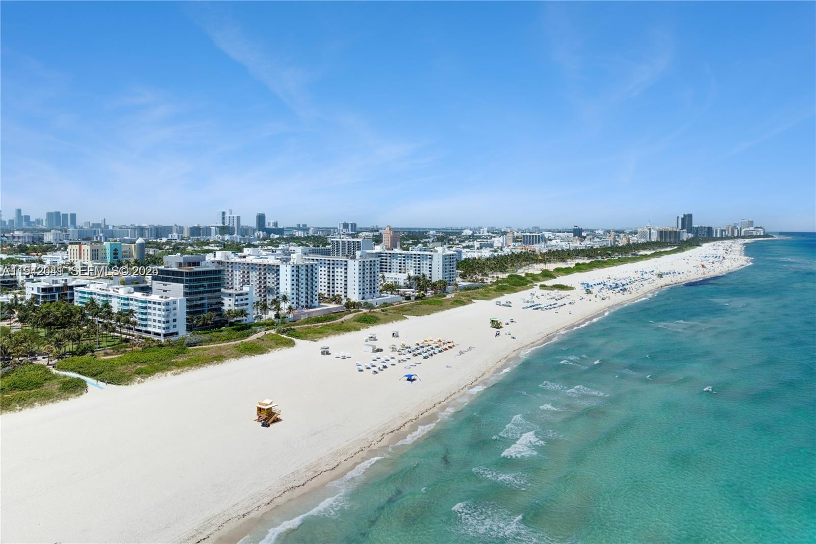 An aerial view shows a white sand beach, turquoise ocean, and coastal high-rise buildings — 301 Ocean Dr # 302, Miami Beach FL 33139, MIAMI BEACH, FL