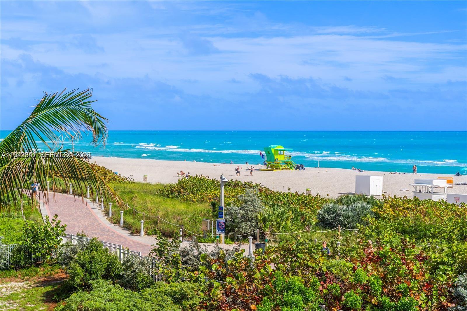 A view of a sandy beach with a bright green lifeguard stand and ocean — 301 Ocean Dr # 302, Miami Beach FL 33139, MIAMI BEACH, FL