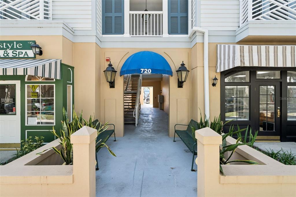 An exterior view shows a building entrance with a blue awning labeled 720 — 720 CELEBRATION AVENUE UNIT 235, CELEBRATION, FL