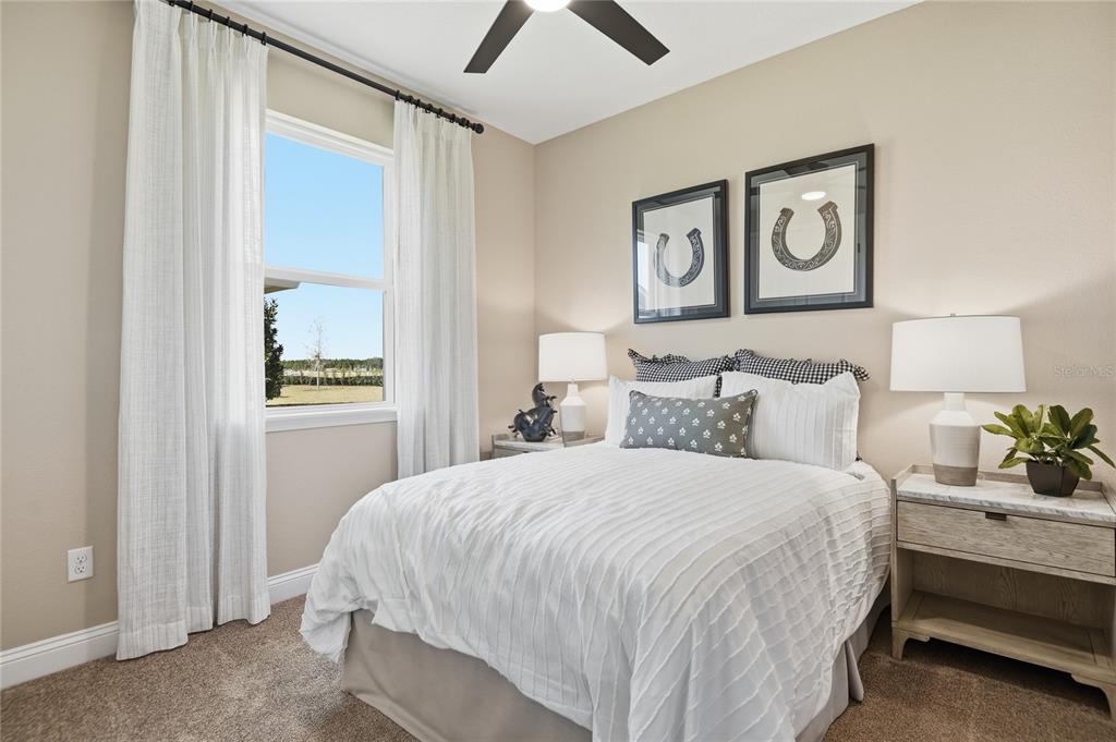 A bedroom features a bed with white bedding, two nightstands, and framed horseshoe wall art — 203 THORNBERRY WAY, PALM COAST, FL