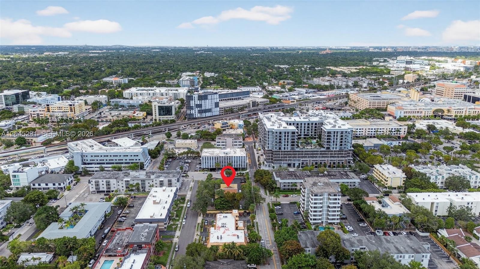 An aerial view shows a multi-story building marked with a red pin in a city — 7420 SW 59th Ave # D, South Miami FL 33143, SOUTH MIAMI, FL