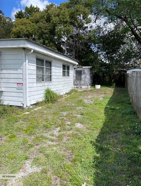 The exterior of a white house with a side yard and a detached shed — 9736 WARRICK STREET, PORT RICHEY, FL