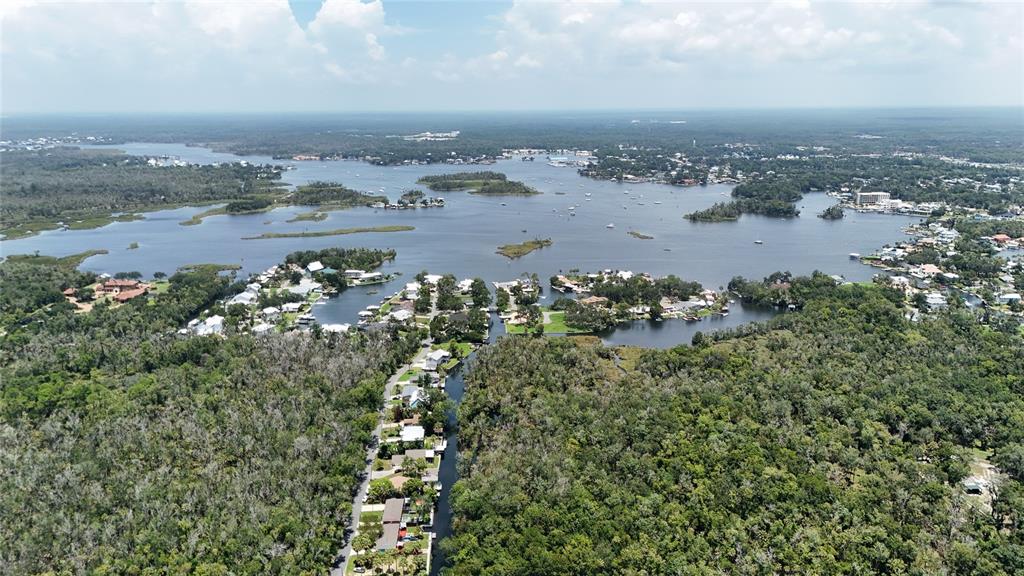 An aerial view shows a residential neighborhood situated along a canal leading to a lake — 9981 W FANWOOD LANE, CRYSTAL RIVER, FL