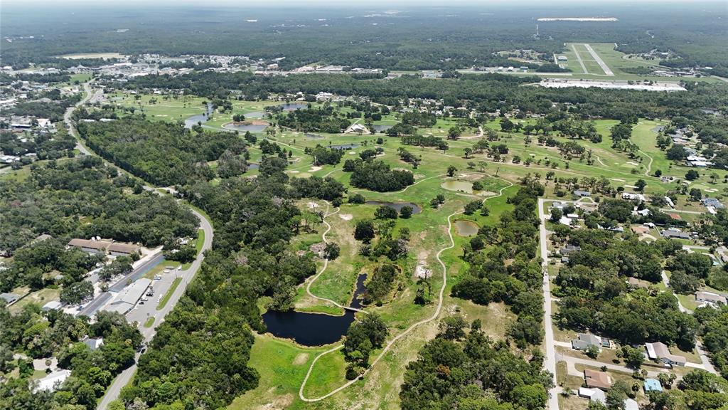 An aerial view shows a golf course with several ponds, walking paths, and surrounding residential areas — 9981 W FANWOOD LANE, CRYSTAL RIVER, FL