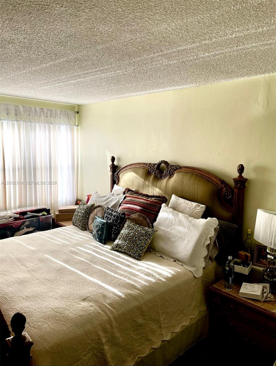 A bedroom features a large wooden headboard, a made bed with multiple pillows, and a window — 3301 Spanish Moss Ter # 510, Lauderhill FL 33319, LAUDERHILL, FL