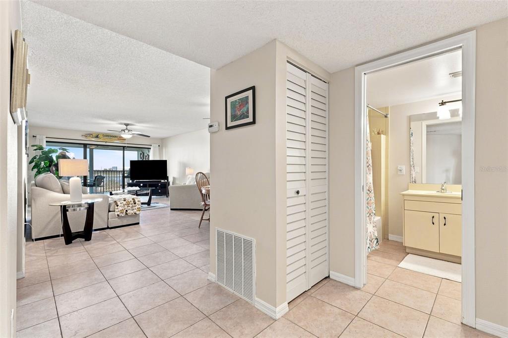 A living room with tile floors leads to a bathroom with a vanity and shower — 3601 S BANANA RIVER BOULEVARD UNIT A304, COCOA BEACH, FL