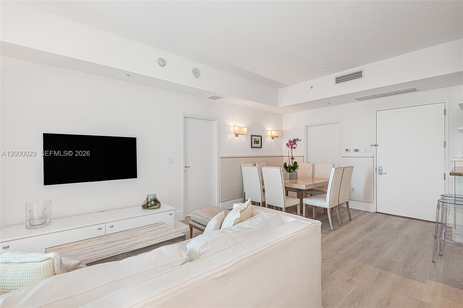 A living and dining area features white walls, light wood flooring, and modern furniture — 50 S Pointe Dr # 1804, Miami Beach FL 33139, MIAMI BEACH, FL