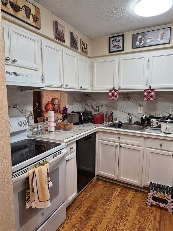 A kitchen features white cabinets, marble-look countertops, a black dishwasher, and a white electric stove — 2856 N POWERS DRIVE UNIT 114, ORLANDO, FL