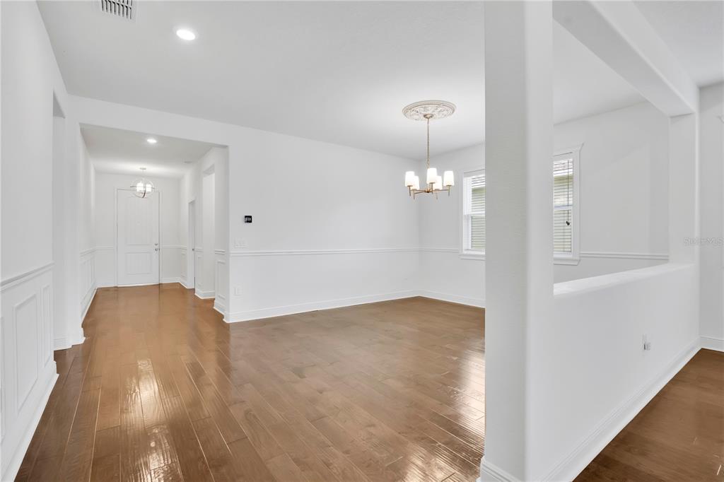 A bright dining room with hardwood floors, white wainscoting, and a chandelier — 14254 SERANOA DRIVE, ORLANDO, FL