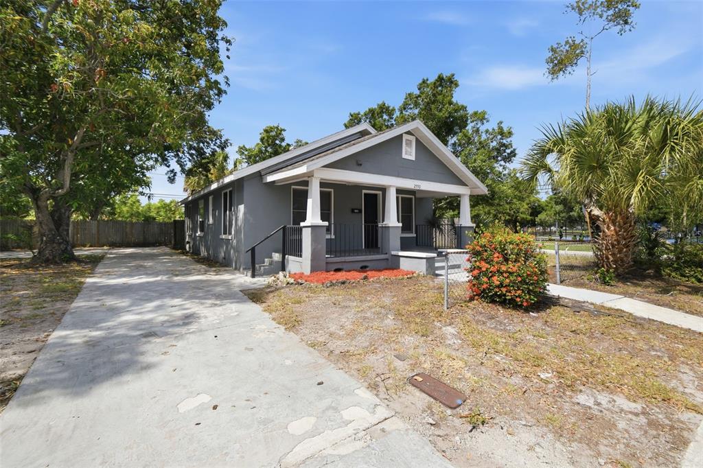 A grey, single-story house with a front porch and a concrete driveway — 2550 10TH AVENUE S, ST PETERSBURG, FL