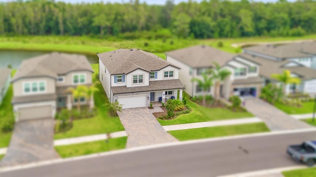 An aerial view of a two-story suburban house with a paved driveway and grassy lawn — 10726 NEW MORNING DRIVE, TAMPA, FL