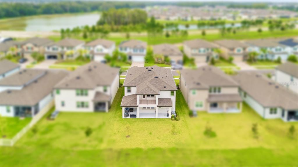 An aerial view shows the rear exterior of a two-story suburban house with a patio — 10726 NEW MORNING DRIVE, TAMPA, FL