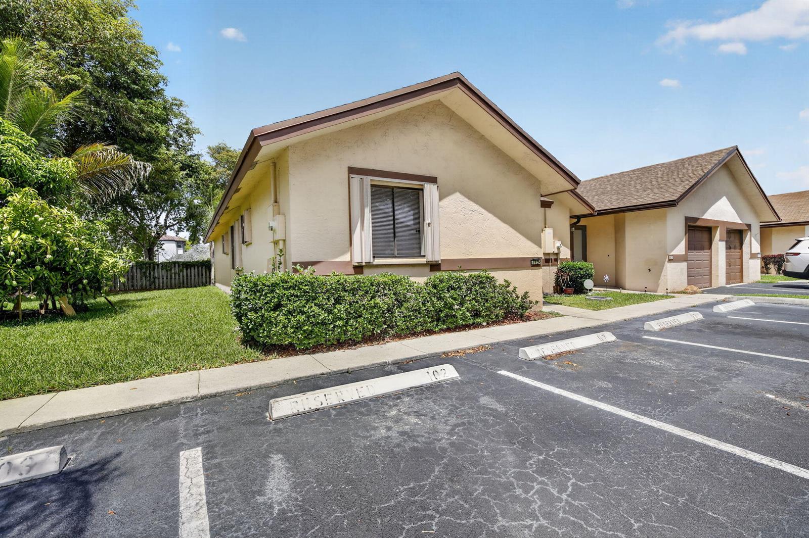 A single-story tan house with a brown roof and reserved parking spaces in the foreground — 11145 NW 38th Place, Sunrise FL 33351, SUNRISE, FL