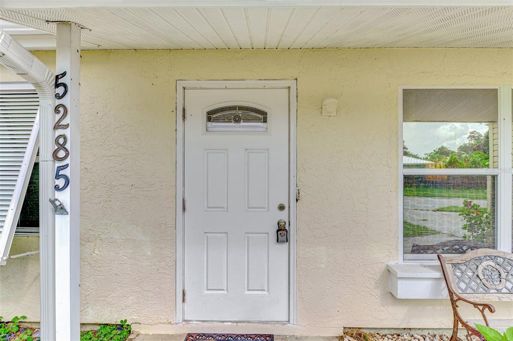A white front door with a small window sits on the exterior of a house — 5285 BROPHY STREET, NORTH PORT, FL