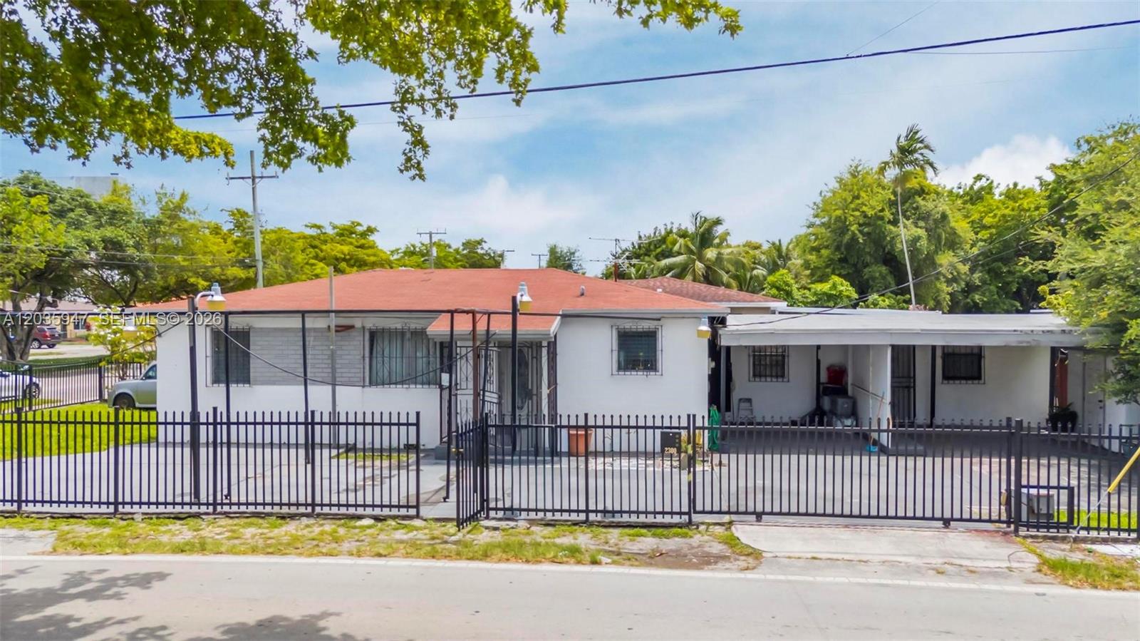 A single-story house with a red roof, white exterior, and a black metal fence — 2300 NW 9th St, Miami FL 33125, MIAMI, FL