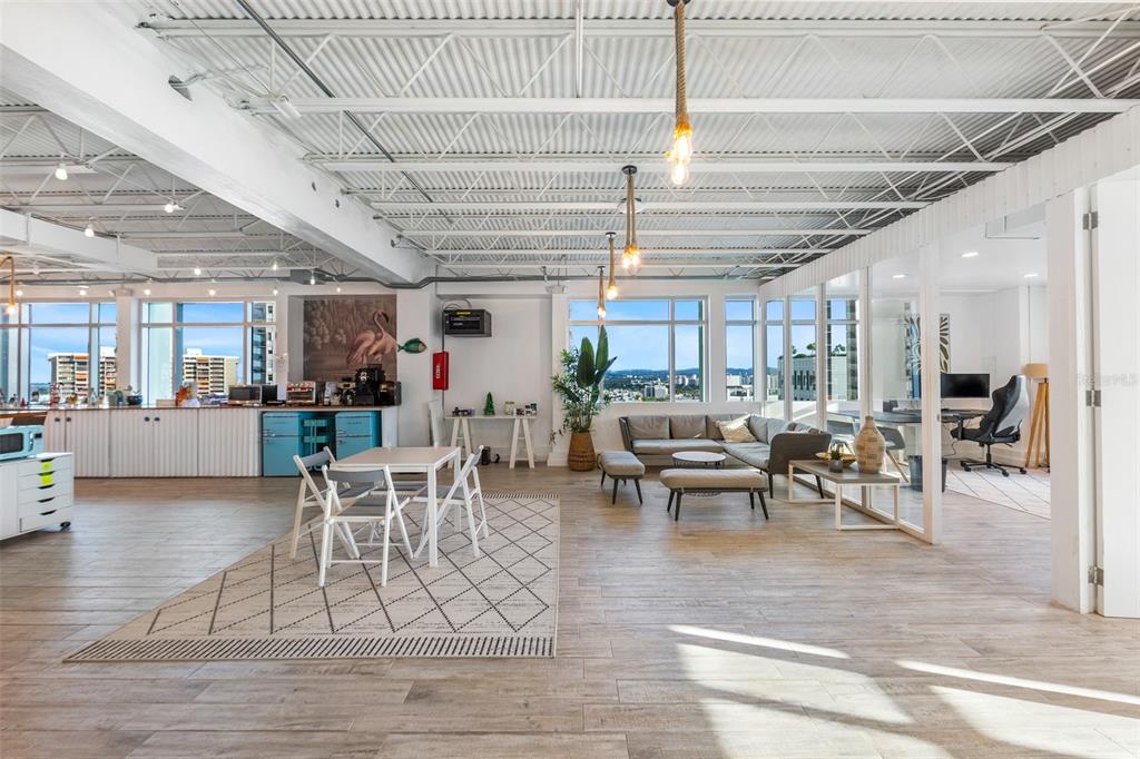 An open-concept office space features a kitchenette, a lounge area, and floor-to-ceiling windows — 1519, Parada 23 AVE. PONCE DE LEÓN, ESQ CALLE DEL PARQUE, SAN JUAN, PR
