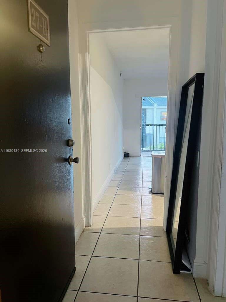 A view through an open doorway shows a tiled hallway leading to a balcony — 4435 Treehouse Ln # H, Tamarac FL 33319, TAMARAC, FL