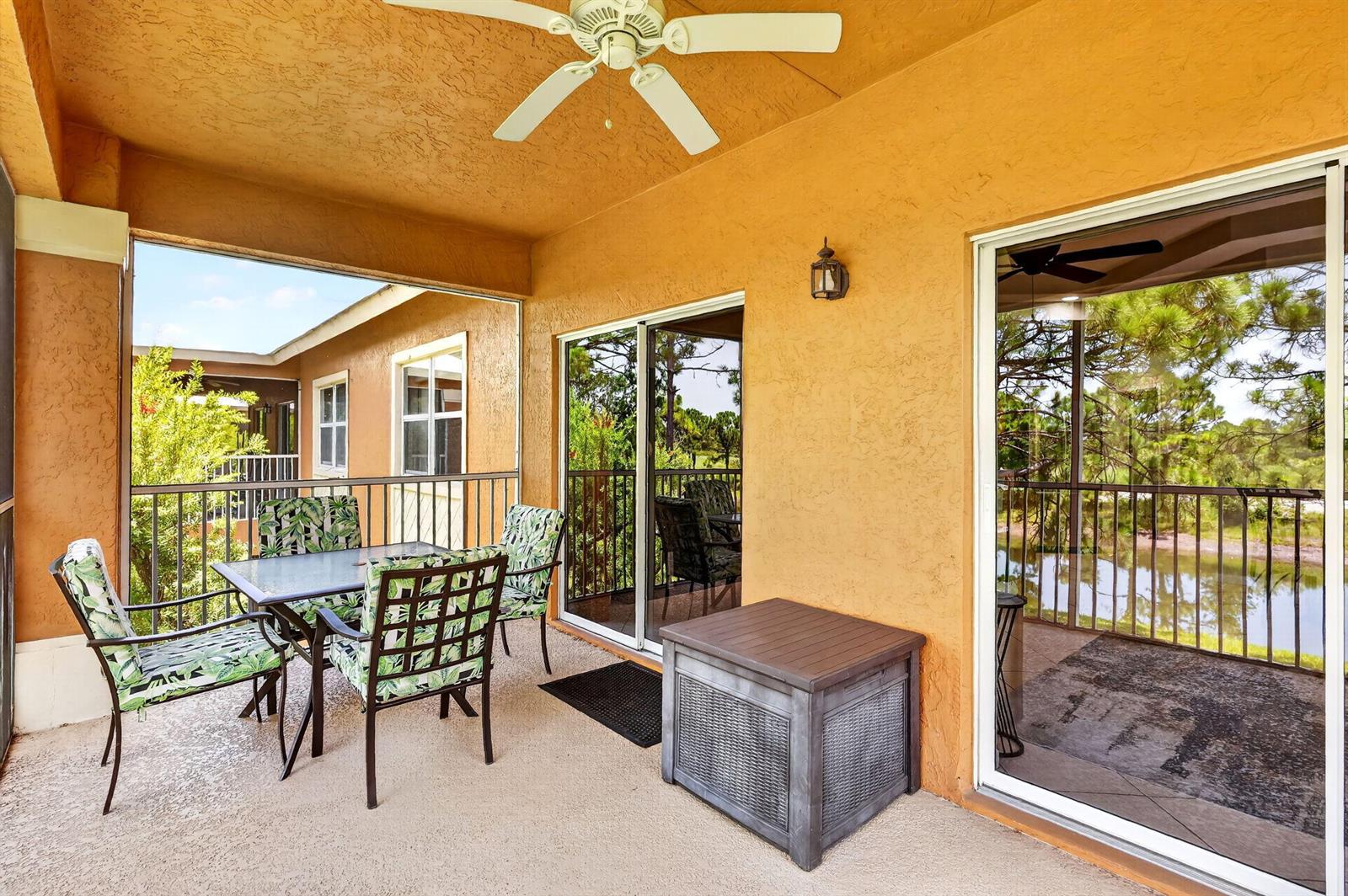 A covered patio features a dining set, a storage chest, and views of a pond — 8326 Mulligan Circle # 2123, FL 34986, FL