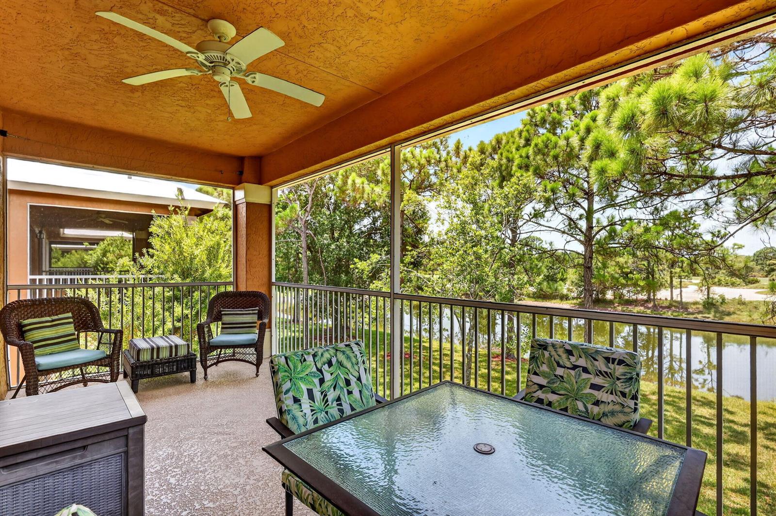 A screened-in balcony with outdoor furniture, a ceiling fan, and a view of a pond — 8326 Mulligan Circle # 2123, FL 34986, FL