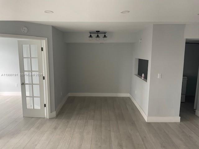 A room with light gray walls, wood-look flooring, a French door, and a ceiling light — 8305 SW 152nd Ave # 406, Miami FL 33193, MIAMI, FL