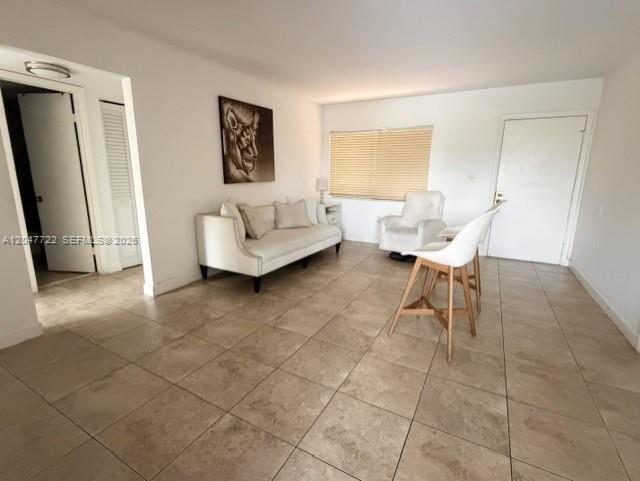 A living room features a beige sofa, a white chair, and a high-top table — 8700 SW 133rd Ave Rd # 302, Miami FL 33183, MIAMI, FL