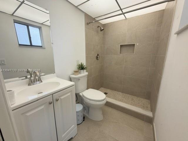 A bathroom features a white vanity, a toilet, and a tiled walk-in shower — 8700 SW 133rd Ave Rd # 302, Miami FL 33183, MIAMI, FL