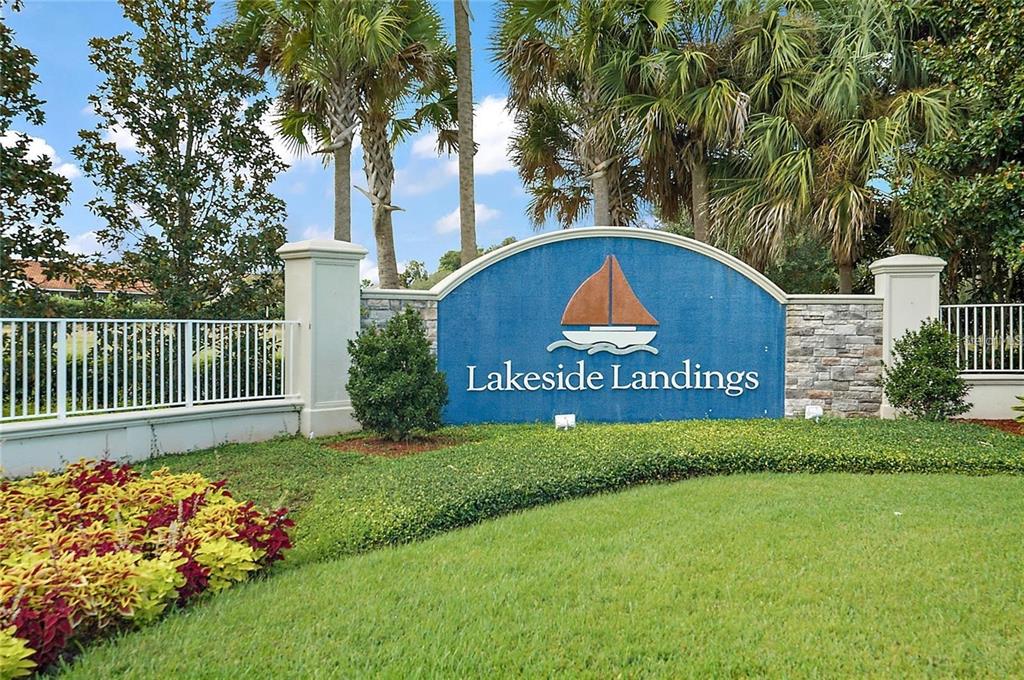 A blue arched sign with a sailboat graphic marks the entrance to Lakeside Landings — 4986 BELTED KINGFISHER DRIVE, OXFORD, FL