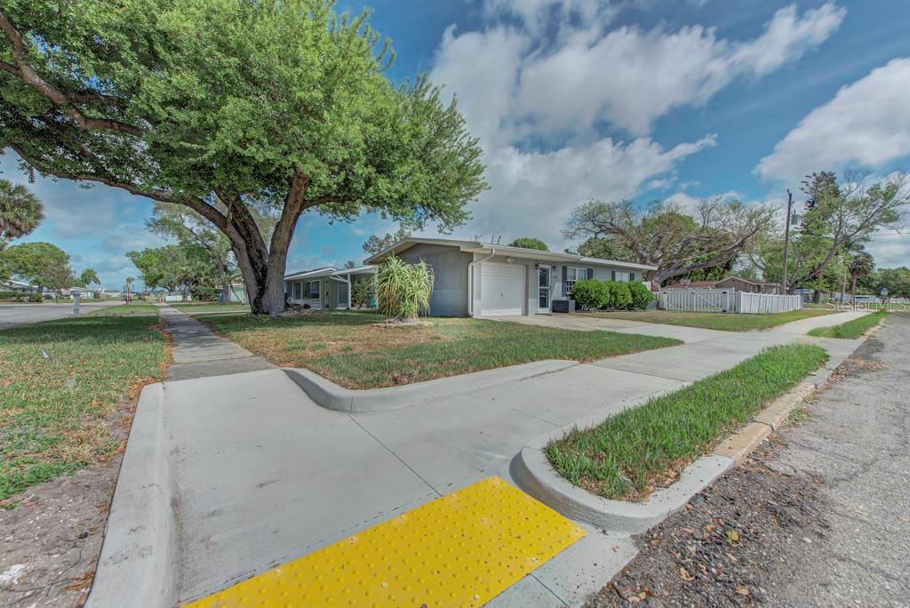 A single-story house with a gray exterior, a garage, and a large tree in front — 1202 26TH AVENUE W, PALMETTO, FL