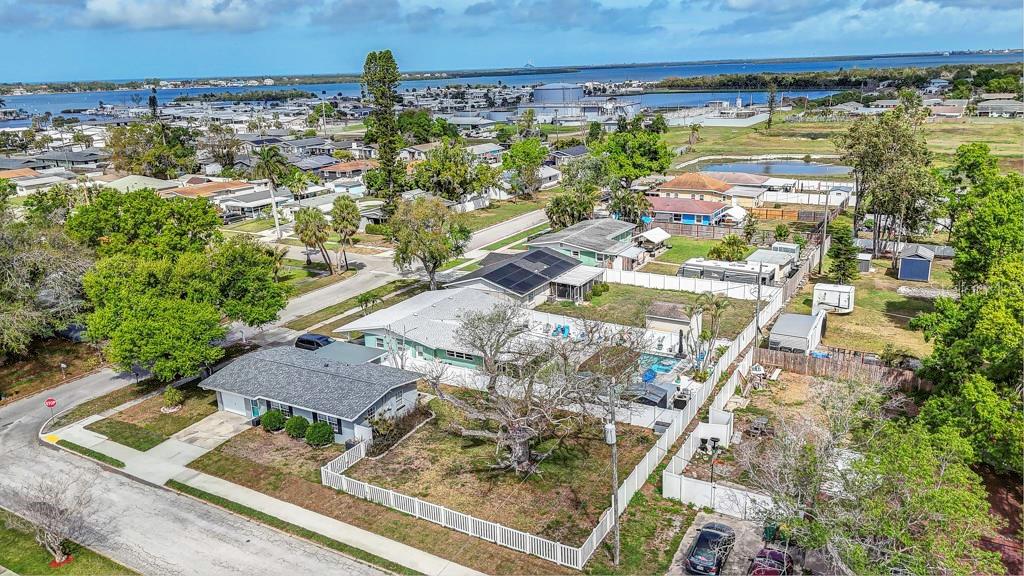 An aerial view shows a residential property with a fenced yard, pool, and detached garage — 1202 26TH AVENUE W, PALMETTO, FL