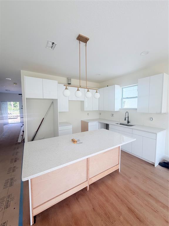 A kitchen under construction features white cabinets, a quartz-topped island, and a linear pendant light — 3601 N 52ND STREET, TAMPA, FL