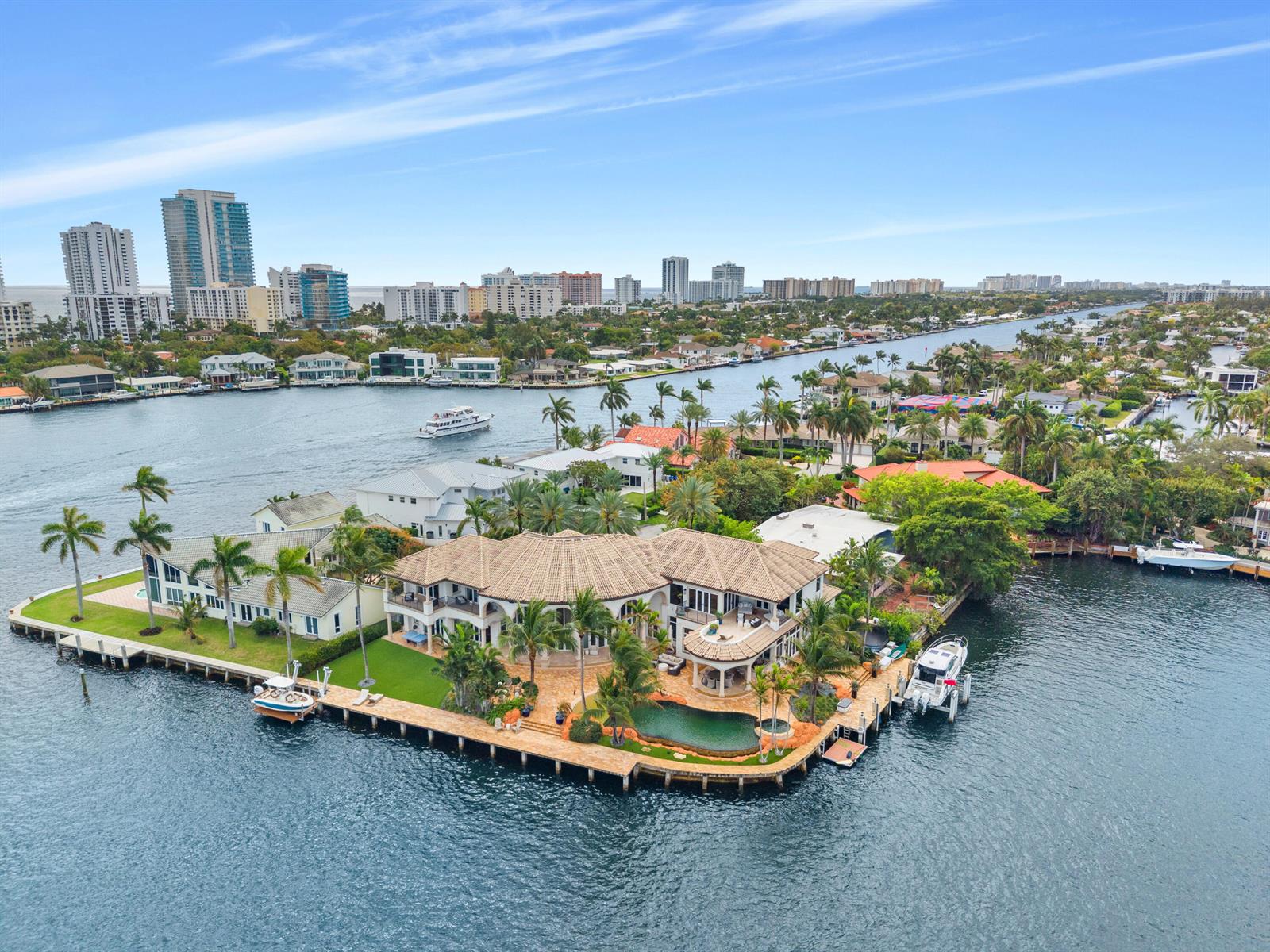 An aerial view of a waterfront mansion with a pool, boat dock, and palm trees — 2593 SE 8th Street, Pompano Beach FL 33062, POMPANO BEACH, FL