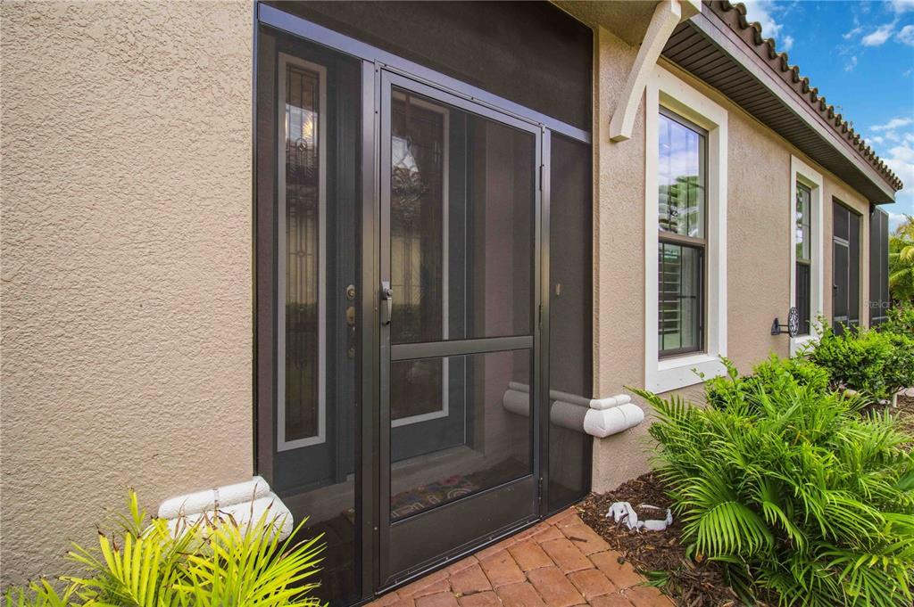 A single-story house with a brown tile roof, a two-car garage, and a brick driveway — 10437 HIGHLAND PARK PLACE, PALMETTO, FL