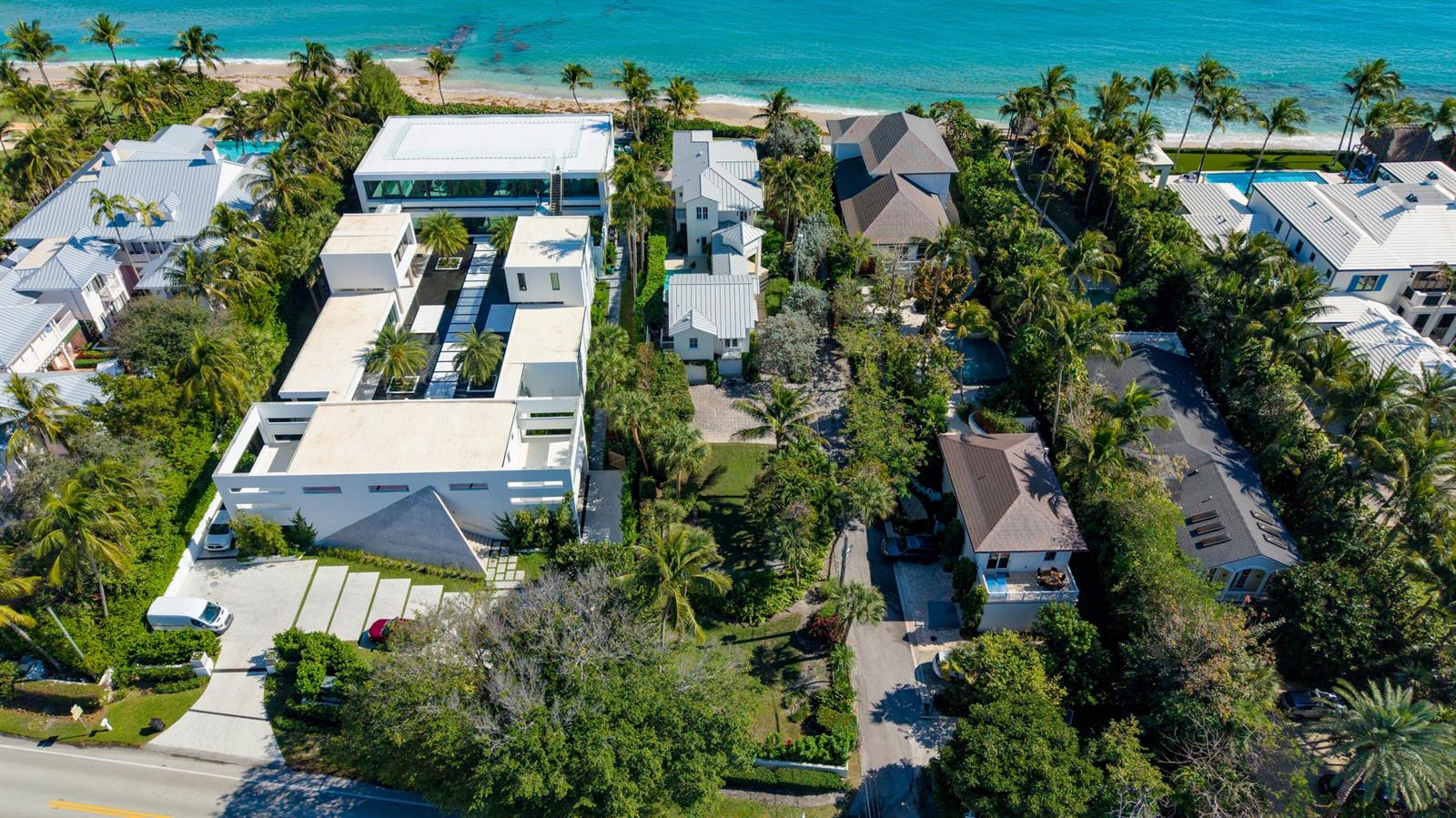 An aerial view shows several modern and traditional houses nestled among lush trees near the ocean — 6201 N Ocean Boulevard, Ocean Ridge FL 33435, OCEAN RIDGE, FL