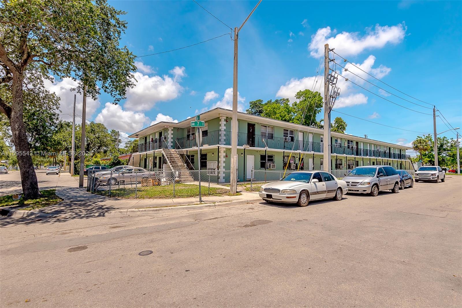 A two-story, light green apartment building stands on a corner lot with parked cars — 5600 NW 7th Ct # 14, Miami FL 33127, MIAMI, FL